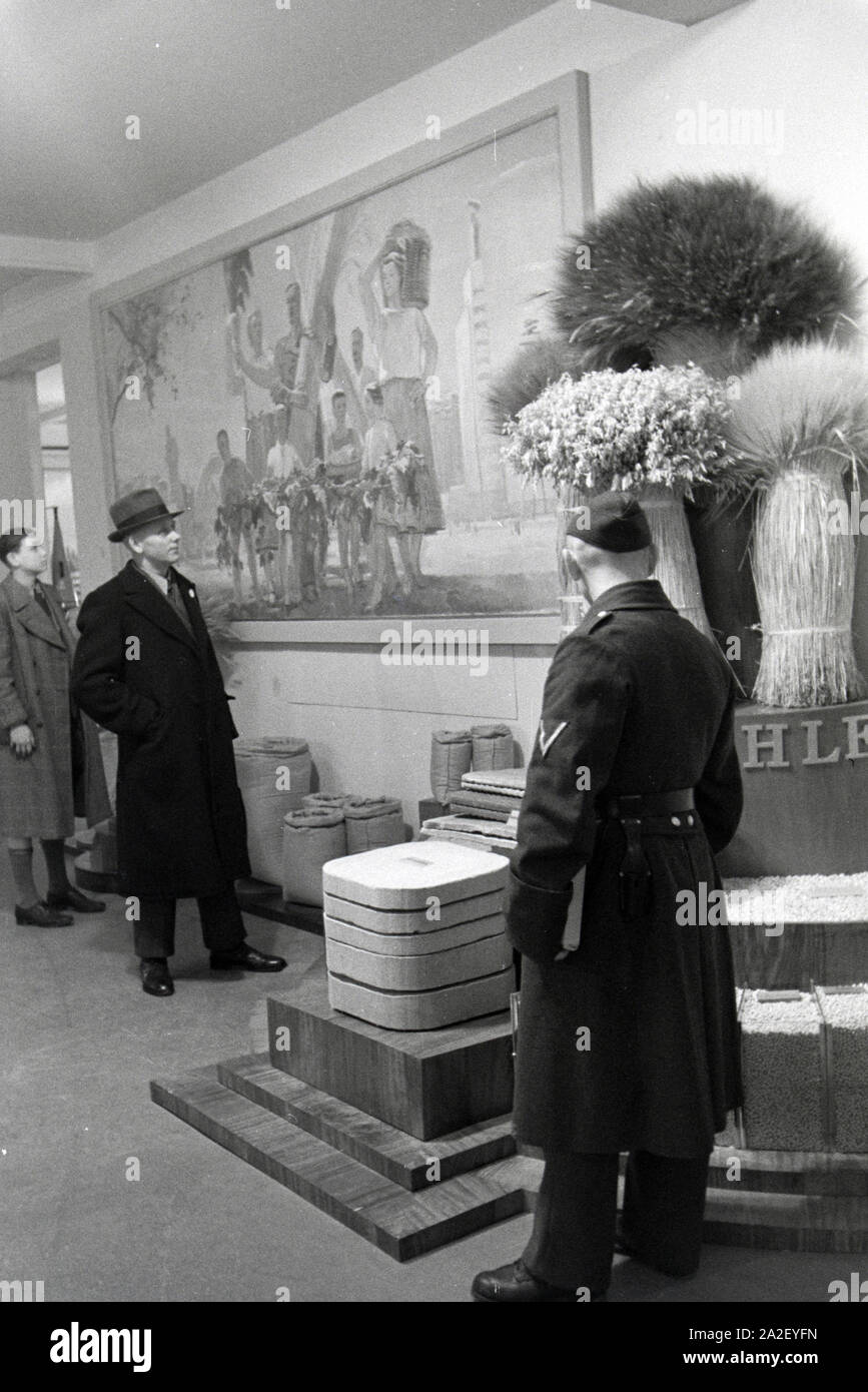 Besucher der Leipziger Frühjahrsmesse vor einem Informationsstand bzgl. des Getreideanbaus, Deutschland 1941. I visitatori della Leipziger Frühjahrsmesse davanti a un banco informazioni per quanto riguarda la coltivazione e lavorazione del grano, Germania 1941. Foto Stock