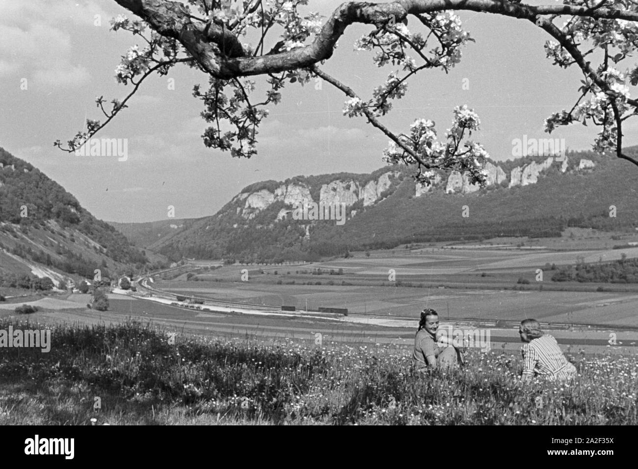 Zwei junge Frauen sitzen im Gras einer Wiese im Schwarzwald, Deutschland 1930er Jahre. Due giovani donne in seduta l'erba su un prato nella Foresta Nera, Germania 1930s. Foto Stock