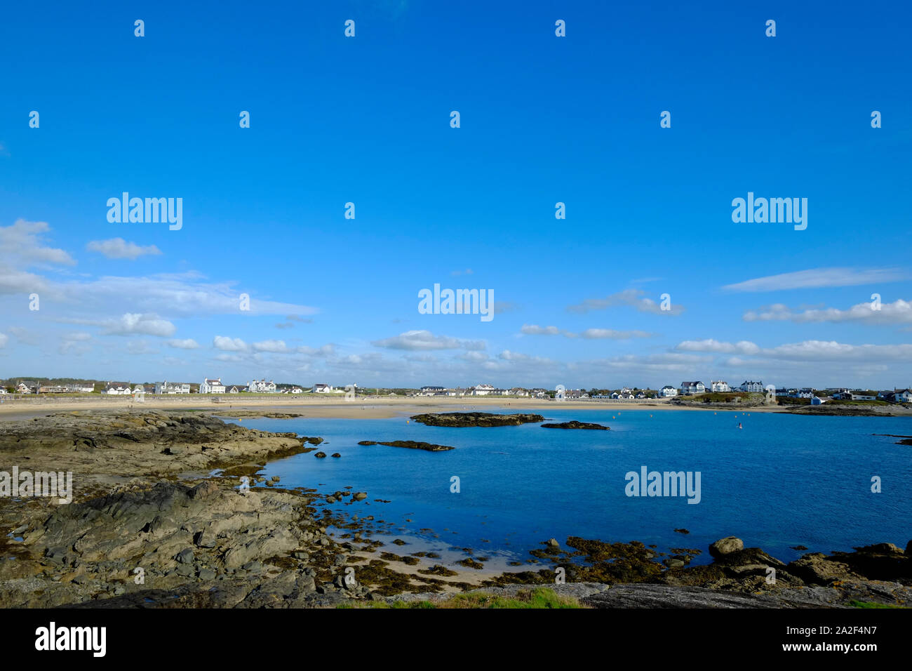 Trearddur la spiaggia e la baia Anglesea Galles del Nord che si affaccia sul mare da un luminoso nel tardo pomeriggio di un estate indiana Foto Stock Trearddur la spiaggia e la baia Anglesea Galles del Nord che si affaccia sul mare da un luminoso nel tardo pomeriggio di un estate indiana Foto Stock