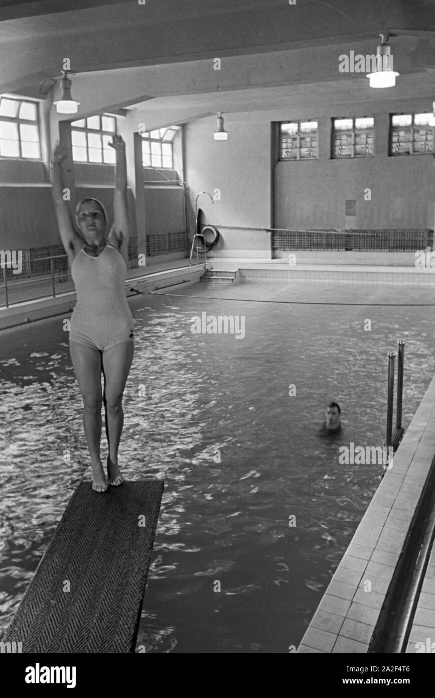 Junge Frau auf dem Sprungturm im Schwimmbad, Freudenstadt, Deutschland 1930er Jahre. Giovane donna in piedi sulla torre di immersioni in piscina, Freudenstadt Germania 1930s. Foto Stock