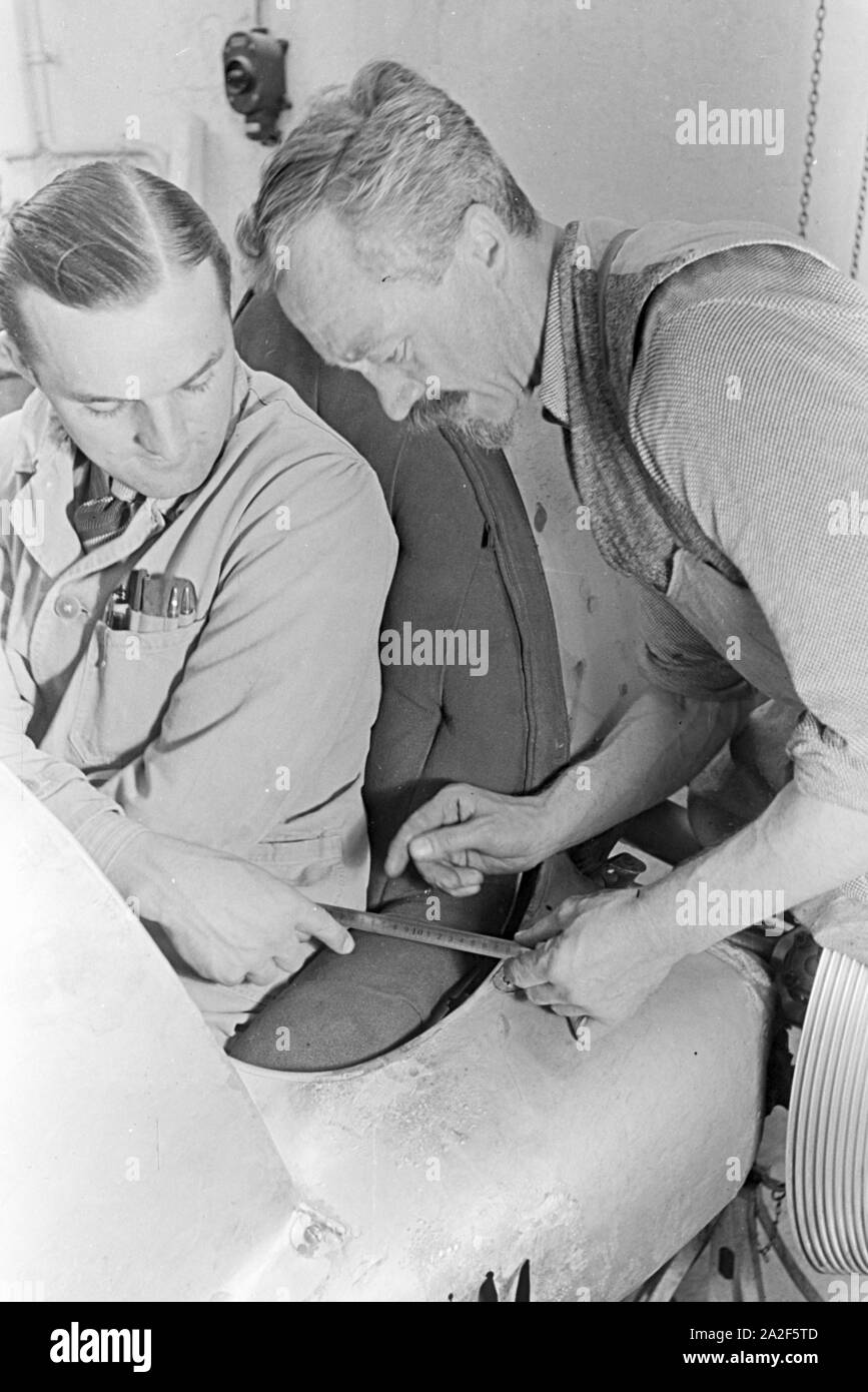 Deutschland; Deutsches Reich; 3.; III.; Drittes Reich; 1930er Jahre; Germania; 3rd; 1930s; Hermann Lang; Rennfahrer; Autorennen; Mercedes; gara automobilistica; auto racing; auto race; racer; race driver; Garage; auto alla stazione di servizio; autoshop; Reparatur; riparazione; Mechaniker; meccanico; Karosserie; corpo vettura; Foto Stock