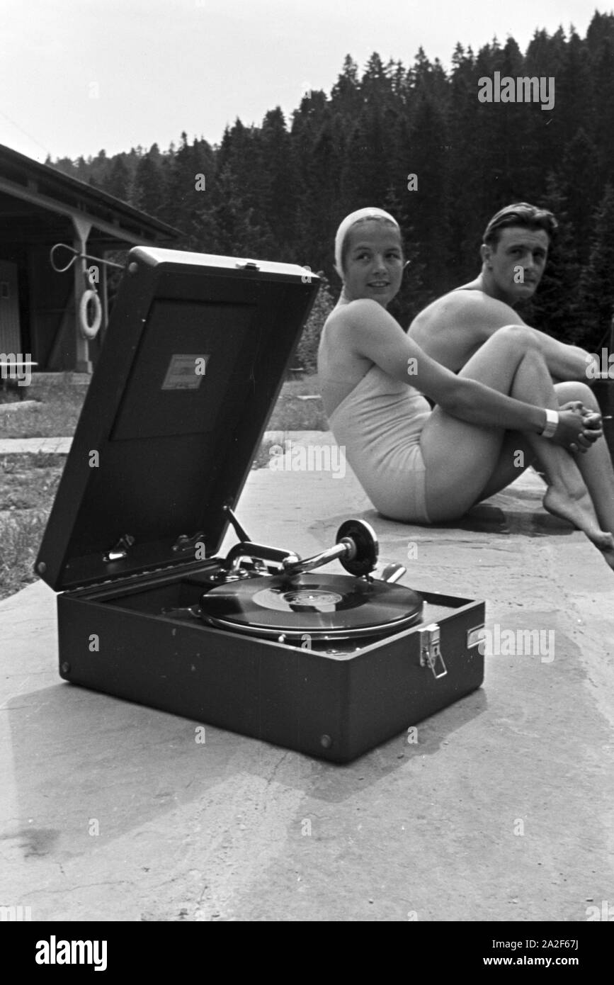 Im Freibad Mit einem Kofferplattenspieler der Marke Electrola, Deutschland 1930er Jahre. La piscina all'aperto con un portatile Electrola record giocatore, Germania 1930s. Foto Stock