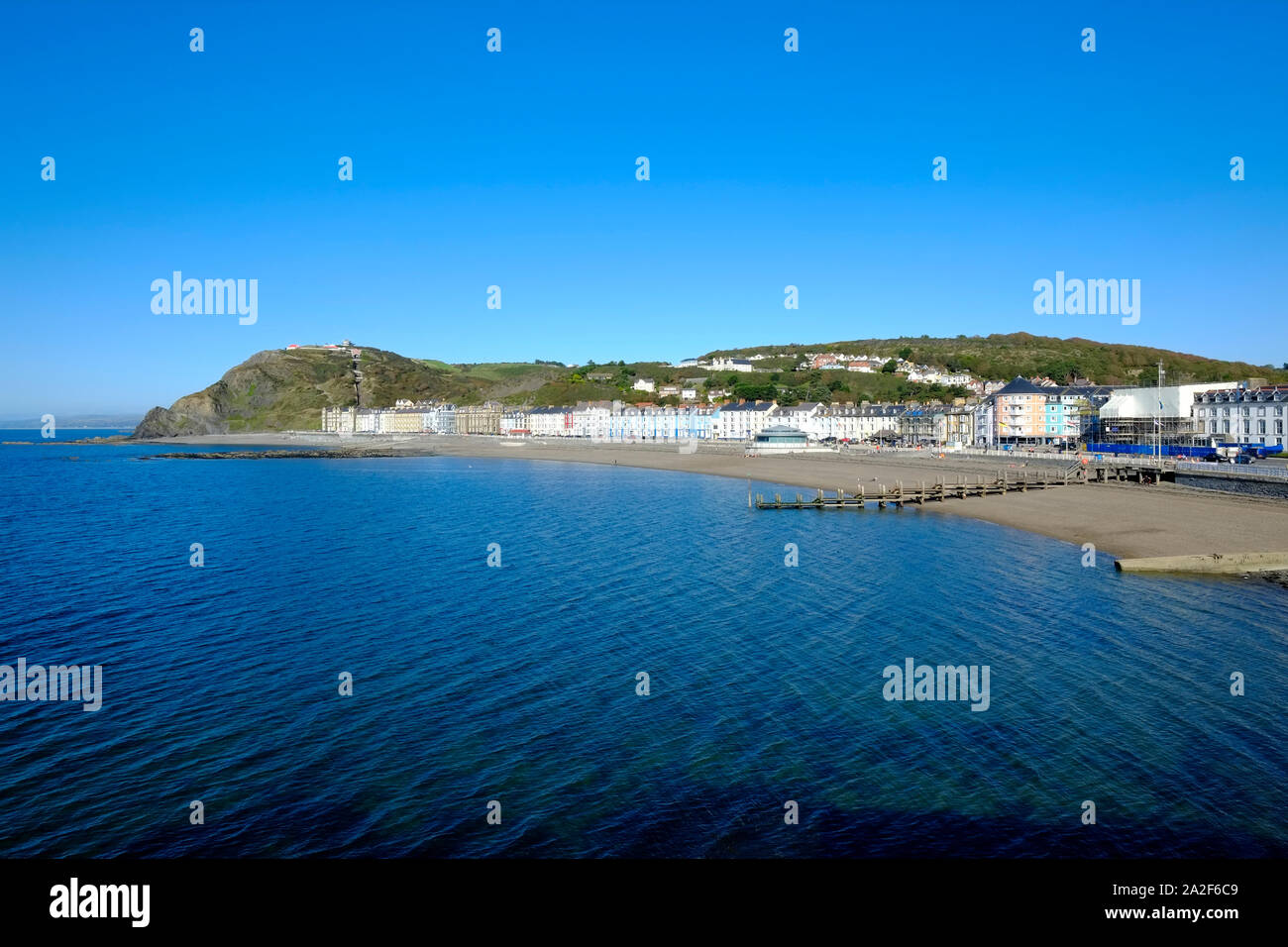 Aberystwyth Town Lungomare spiaggia e il lungomare con la bassa marea in una giornata di sole e il calore di un estate indiana Foto Stock