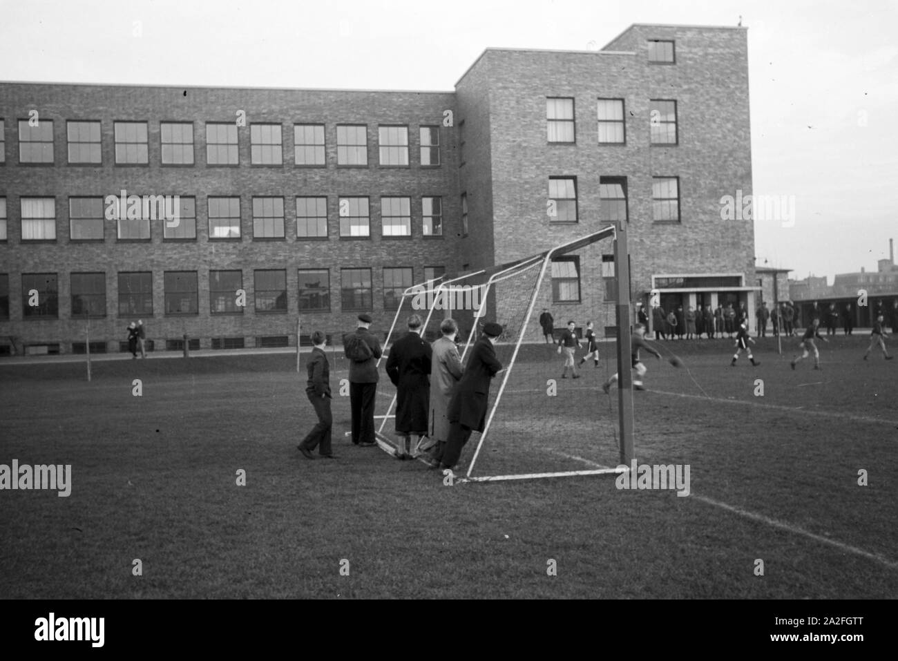 Zuschauer beobachten ein Fußballspiel auf dem Gelände der Roth-Büchner GmbH di Berlino, Deutschland 1930er jahre. Gli spettatori di una partita di calcio sulla zona del Roth-Büchner GmbH di Berlino, Germania 1930s. Foto Stock