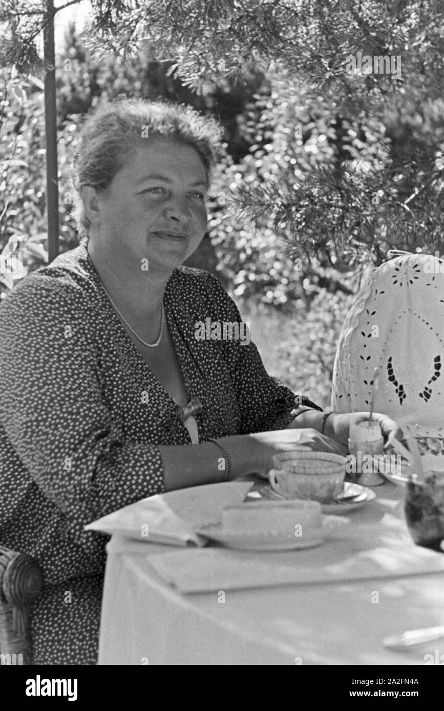 Eine Frau sitzt am Kaffeetisch um Urlaub an der Ostsee, Deutschland 1930er Jahre. Una donna seduta sul tavolino da caffè in lei le vacanze sul Mar Baltico, Germania 1930s. Foto Stock
