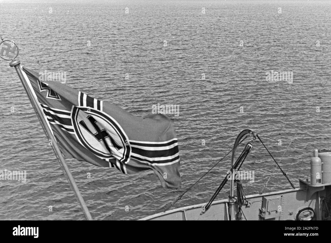 Flagge der Deutschen Kriegsmarine flattert vento im über der Ostsee, Deutschland 1930er Jahre. Bandiera della Germania marina da guerra nel vento al di sopra delle onde del mar Baltico, Germania 1930s. Foto Stock