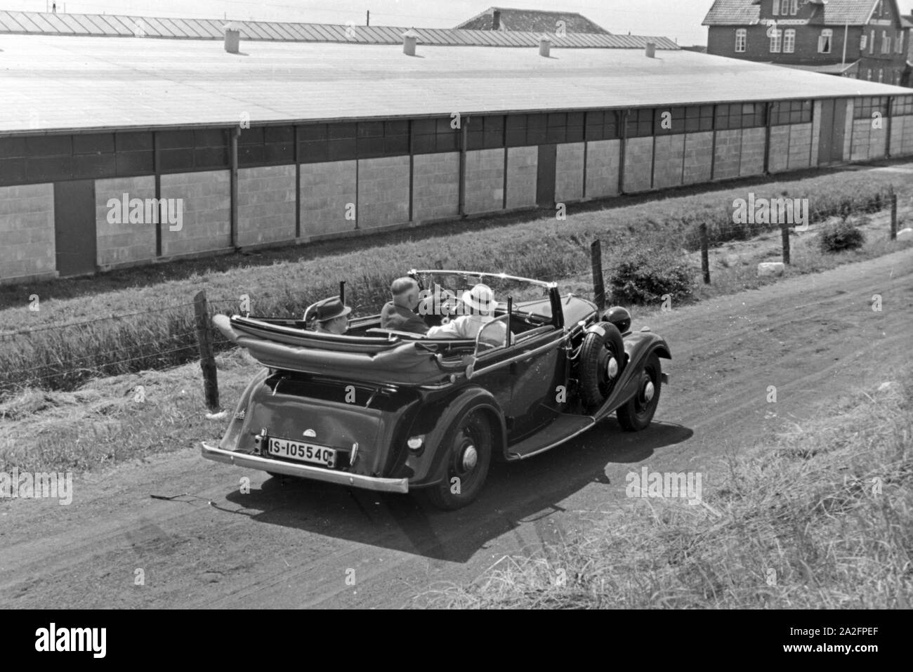 Unterwegs in einem Audi Cabrio zu den Garagen in Norddeich, Deutschland 1930er Jahre. La gente in un'Audi convertibile in garage di Norddeich, Germania 1930s. Foto Stock