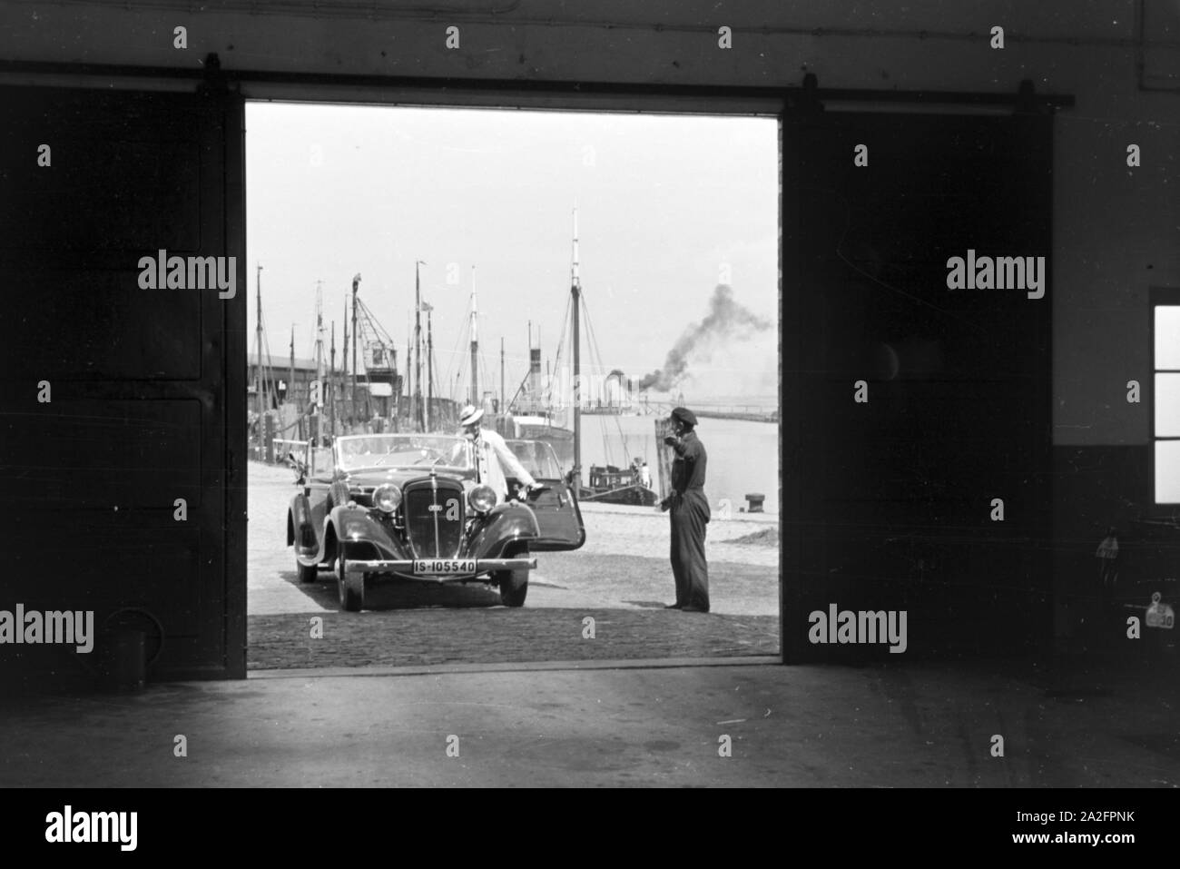 Eine Frau fährt ihr Audi Cabrio in eine der Garagen am Meer in Norddeich, Deutschland 1930er Jahre. Una donna alla guida la sua Audi convertibel in uno dei garage di Norddeich, Germania 1930s. Foto Stock