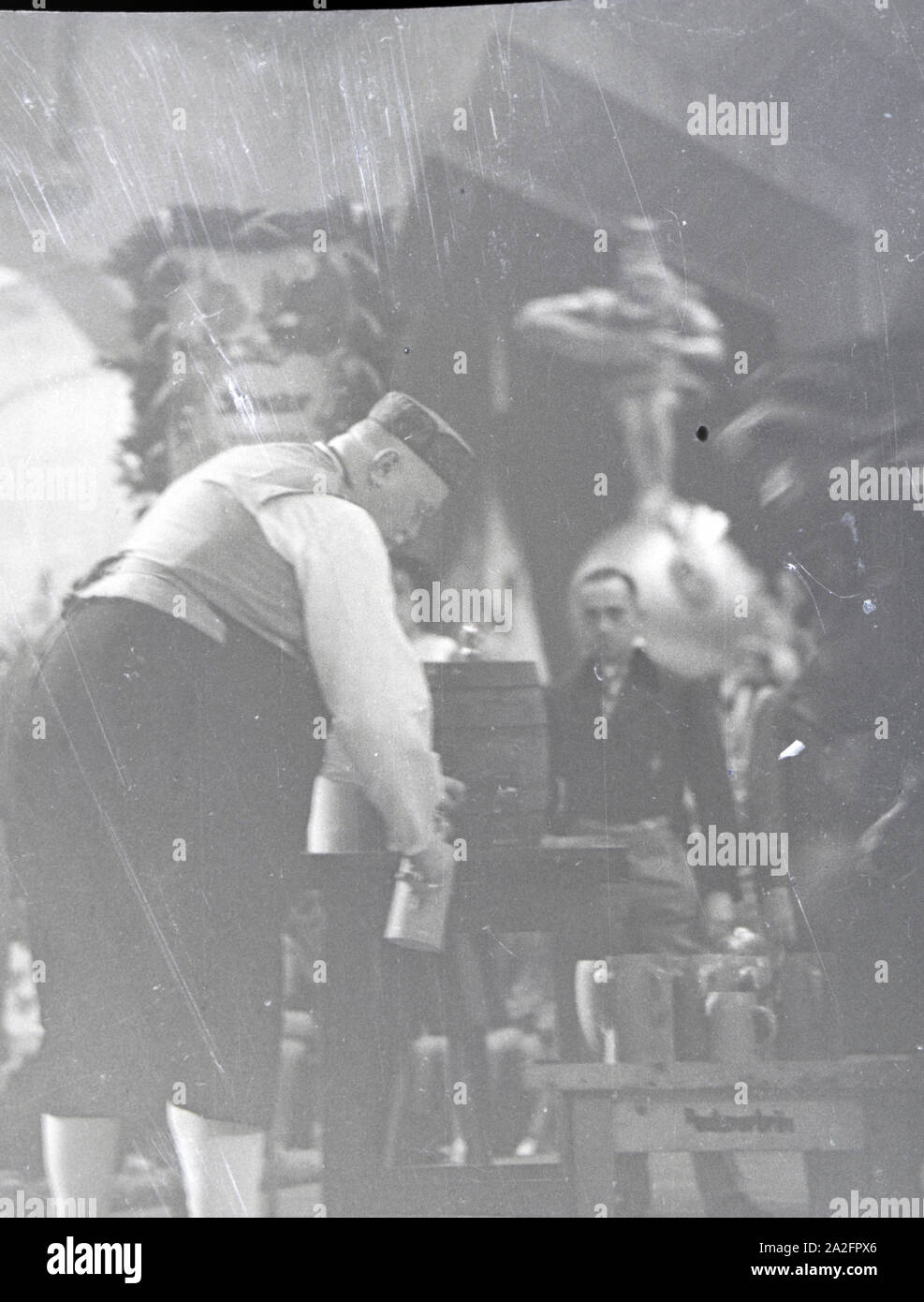 Ein Schankwirt zapft Bier während einer Karnevalsfeier, Deutsches Reich 1937. Un pubblicano il prelievo della birra durante una festa di carnevale, Germania 1937. Foto Stock