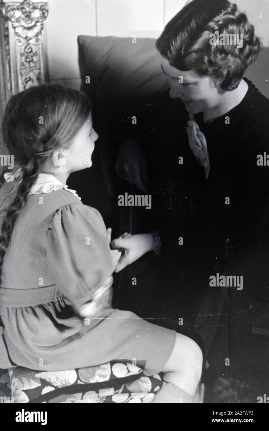 Mitglieder einer kinderreichen Familie helfen sich gegenseitig, Deutsches Reich 1930er Jahre. I membri di una famiglia estesa si aiutano a vicenda, Germania 1930s. Foto Stock