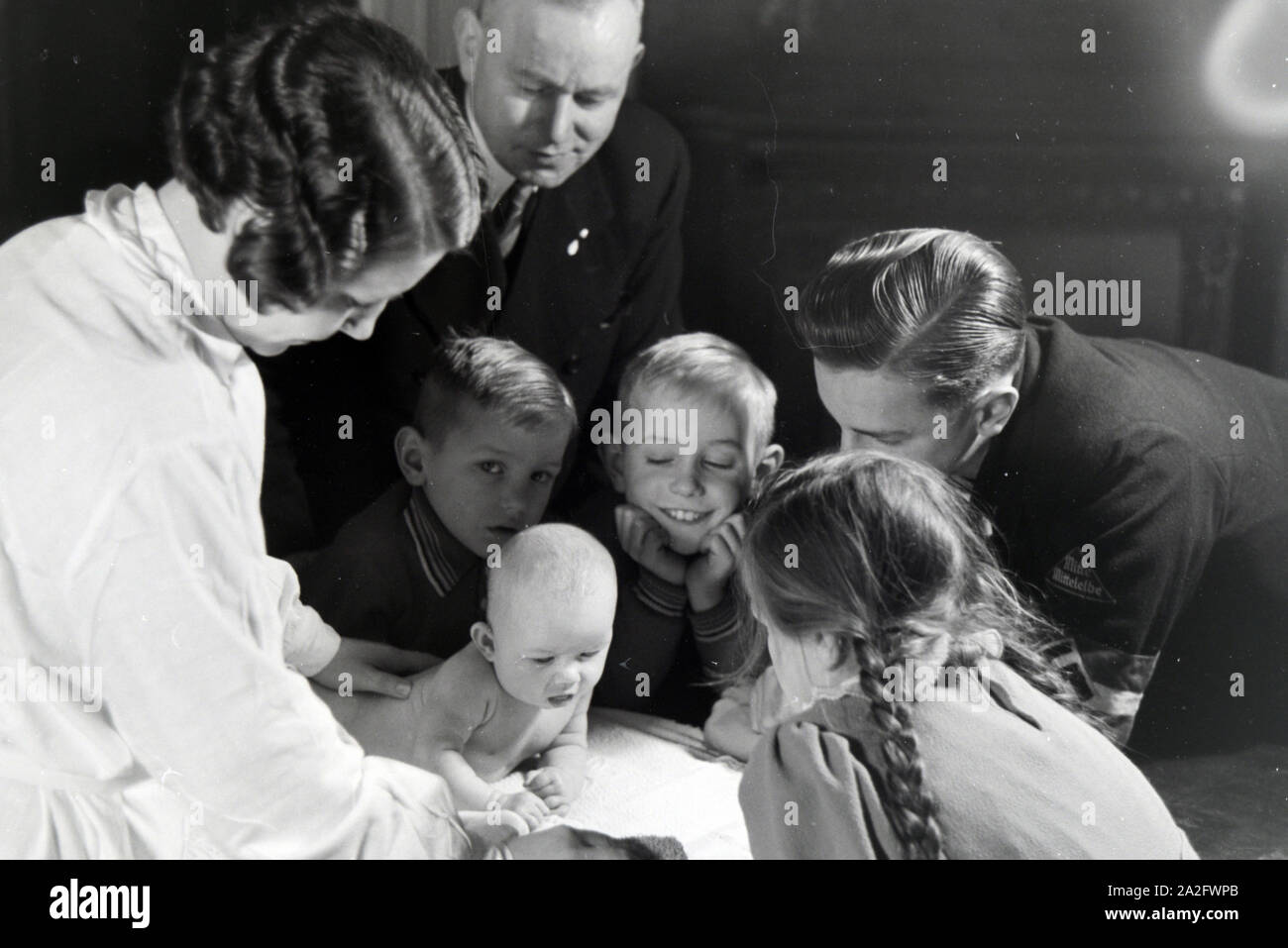 Mitglieder einer kinderreichen Familie mit dem Neugeborenen, Deutsches Reich 1930er Jahre. I membri di una famiglia estesa con il neonato, Germania 1930s. Foto Stock