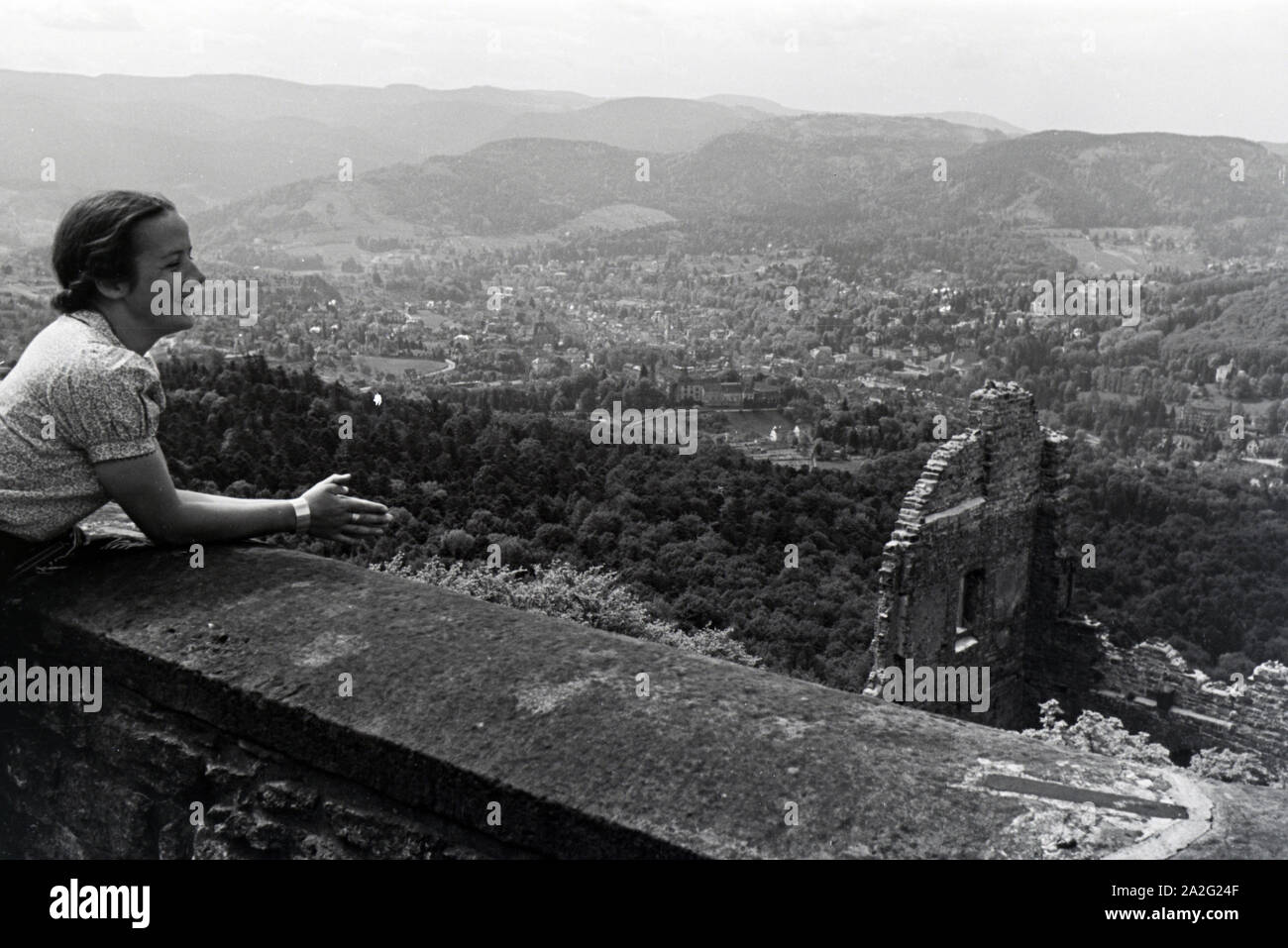 Eine junge Frau genießt den Ausblick von der Schlossruine Hohenbaden Nordschwarzwald im auf die Stadt Baden-Baden, Deutschland 1930er Jahre. Una giovane donna gode della vista su Baden-Baden dalla rovina del castello di Hohenbaden, Germania 1930s. Foto Stock