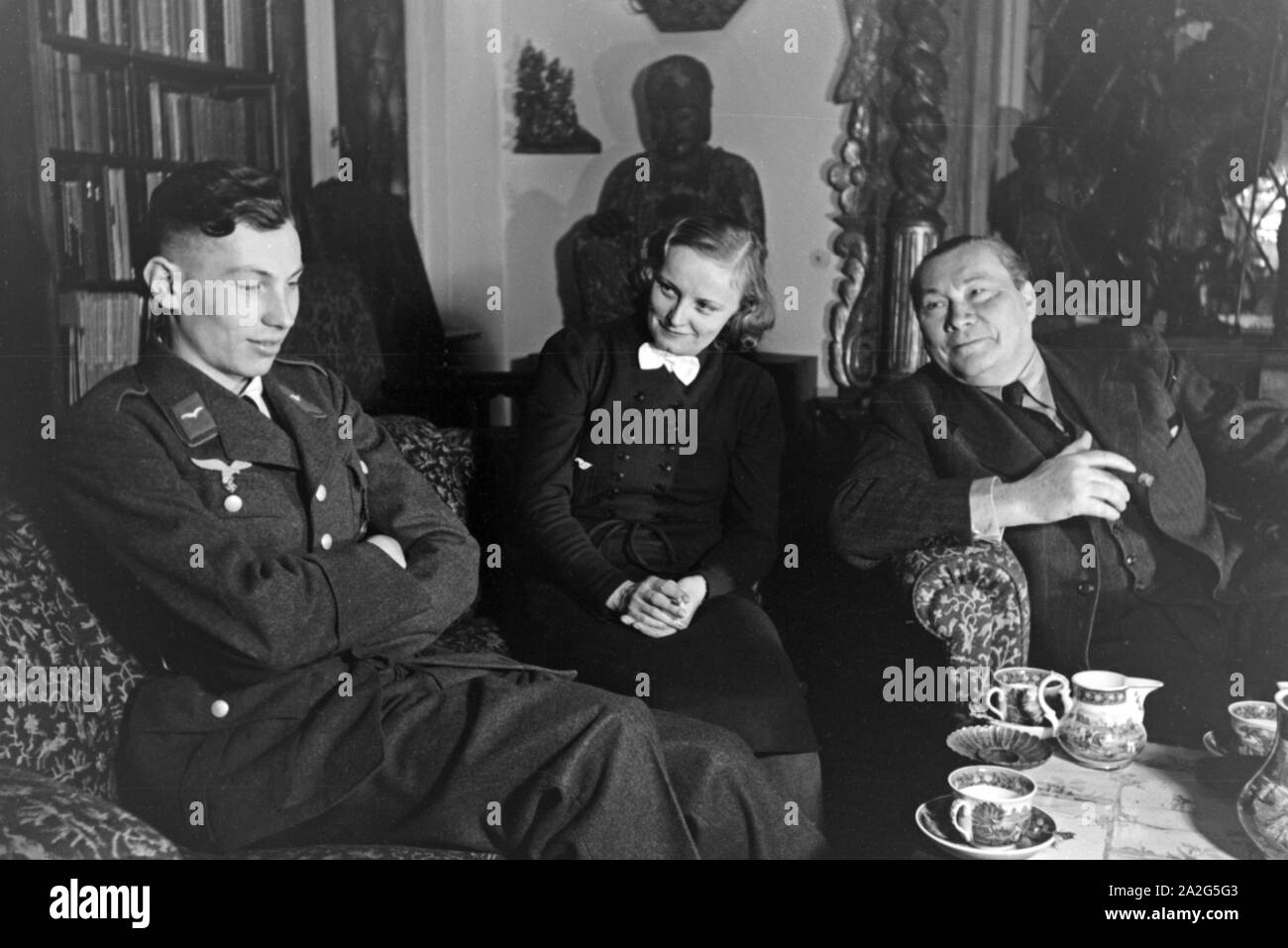 Der deutsche Schauspieler Paul Wegener sitzt Zu Hause mit circuizione Frau, der Schauspielerin Greta Schröder und seinem Sohn Peter, im Wohnhzimmer a Berlino, Deutschland 1930er Jahre. Attore tedesco Paul Wegener di fumare un sigaro mentre è seduto nel suo salotto con sua moglie Greta Schroeder e suo figlio Pietro, nella sua casa di Berlino, Germania 1930s. Foto Stock