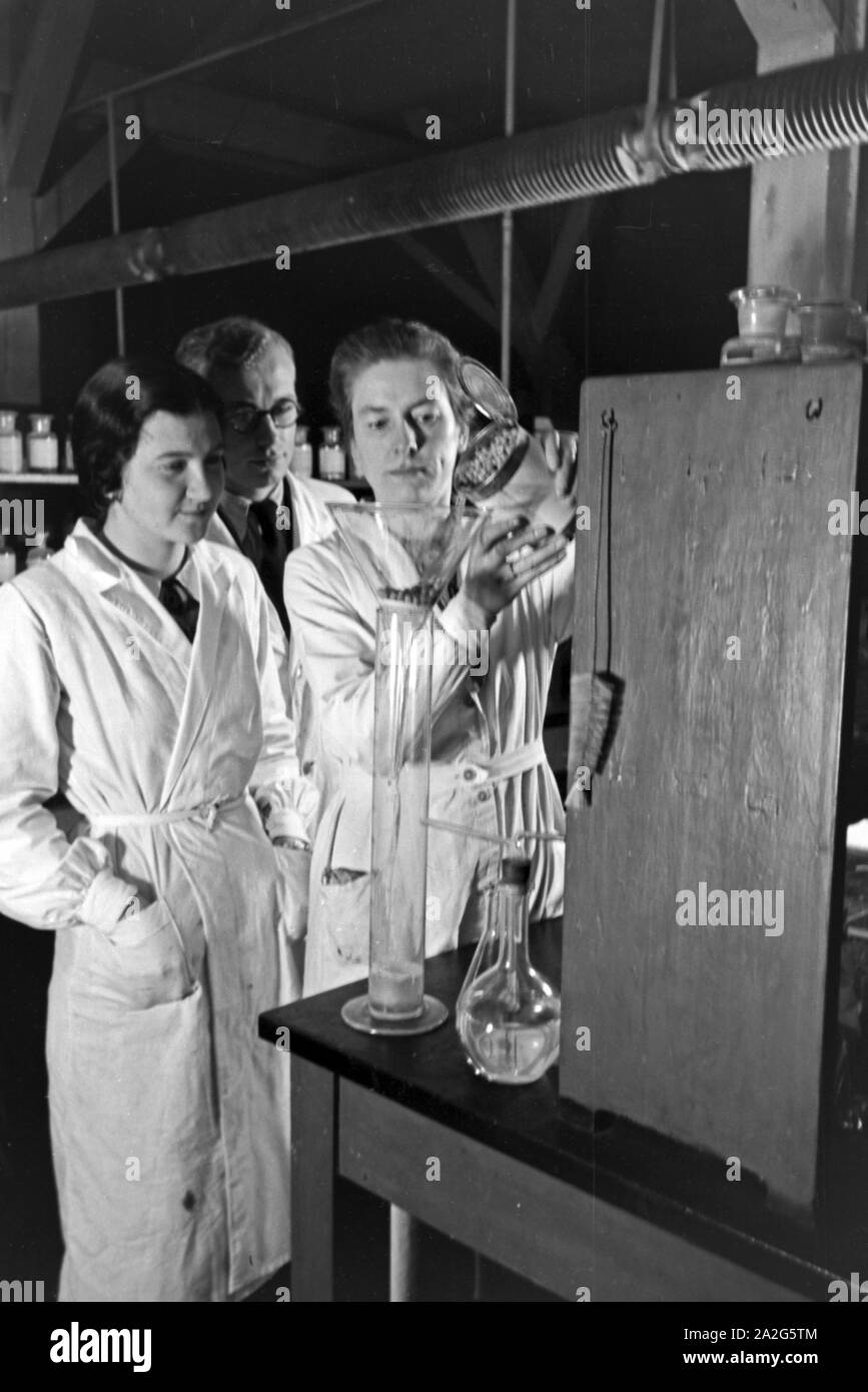 Mitarbeiter bei einer Filterung von Erbsenwasser im Konserventechnikum Magdeburg, Deutschland 1930er Jahre. I membri dello staff filtraggio dell'acqua di una lattina di piselli presso il centro tecnico per i cibi in scatola a Magdeburgo, Germania 1930s. Foto Stock