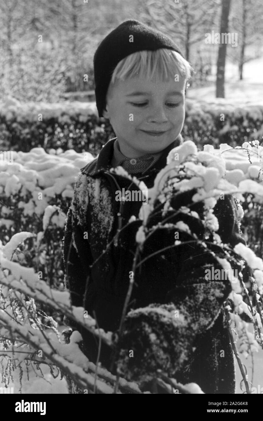 Ein kleiner Junge spielt im Schnee, Deutschland 1930er Jahre. Un ragazzino a giocare nella neve, Germania 1930s. Foto Stock