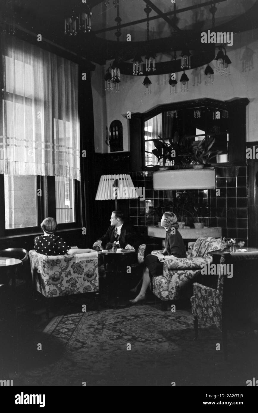 Gäste im Kaminzimmer Schlosshotel im a Oberhof in Turingia, Deutschland 1930er Jahre. Gli ospiti seduti davanti al caminetto a Schlosshotel hotel a Oberhof in Turingia, Germania 1930s. Foto Stock