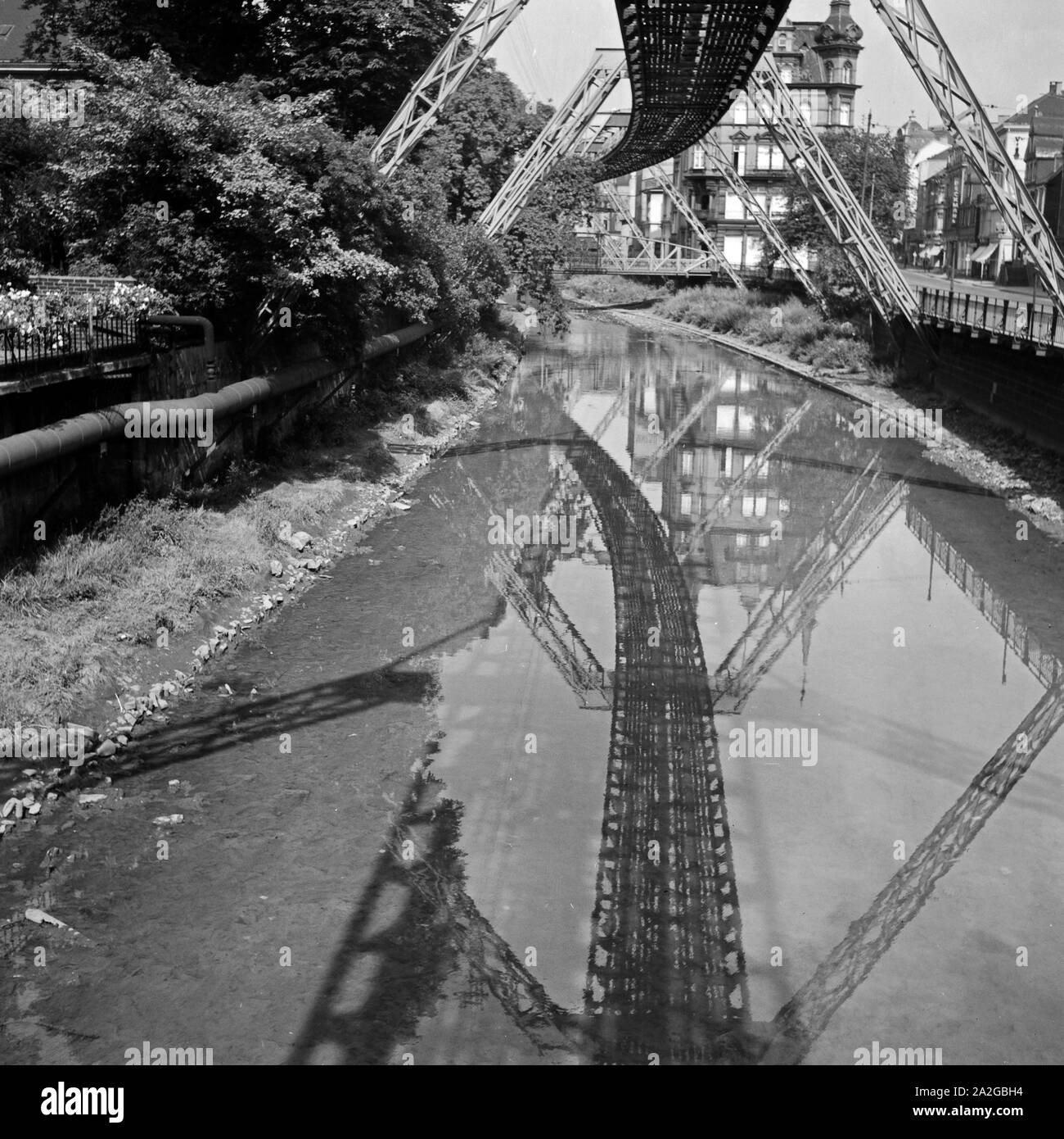 Die Strecke der Wuppertaler Schwebebahn spiegelt sich in der Wupper, Deutschland 1930er Jahre. Wuppertal Ferroviaria di sospensione refelcting nel fiume Wupper, Germania 1930s. Foto Stock