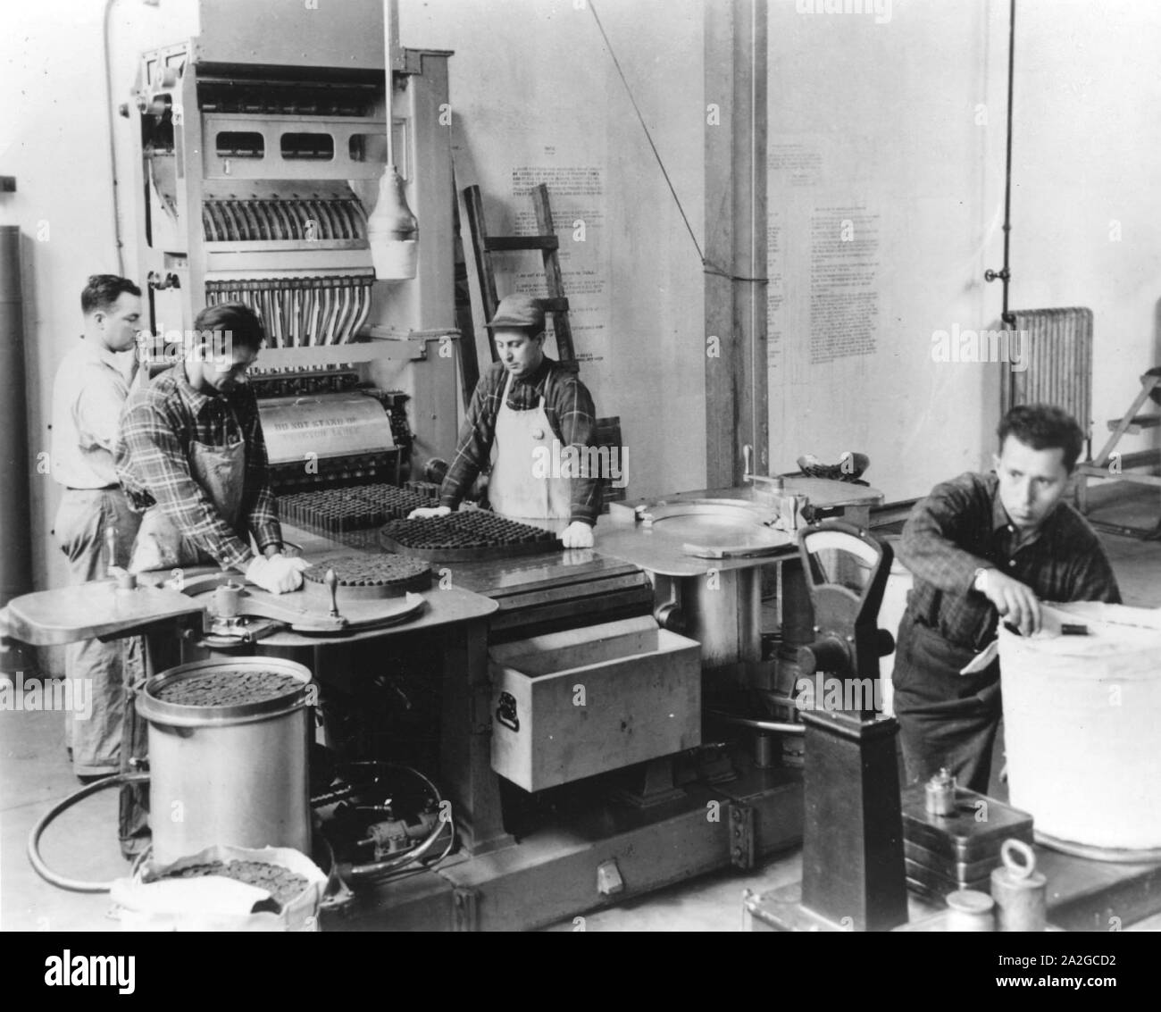 I dipendenti che lavorano con l'Automatico da 16 pollici di impilamento in polvere la macchina a stati uniti Hingham Naval deposito di munizioni durante la Seconda Guerra Mondiale. Foto Stock