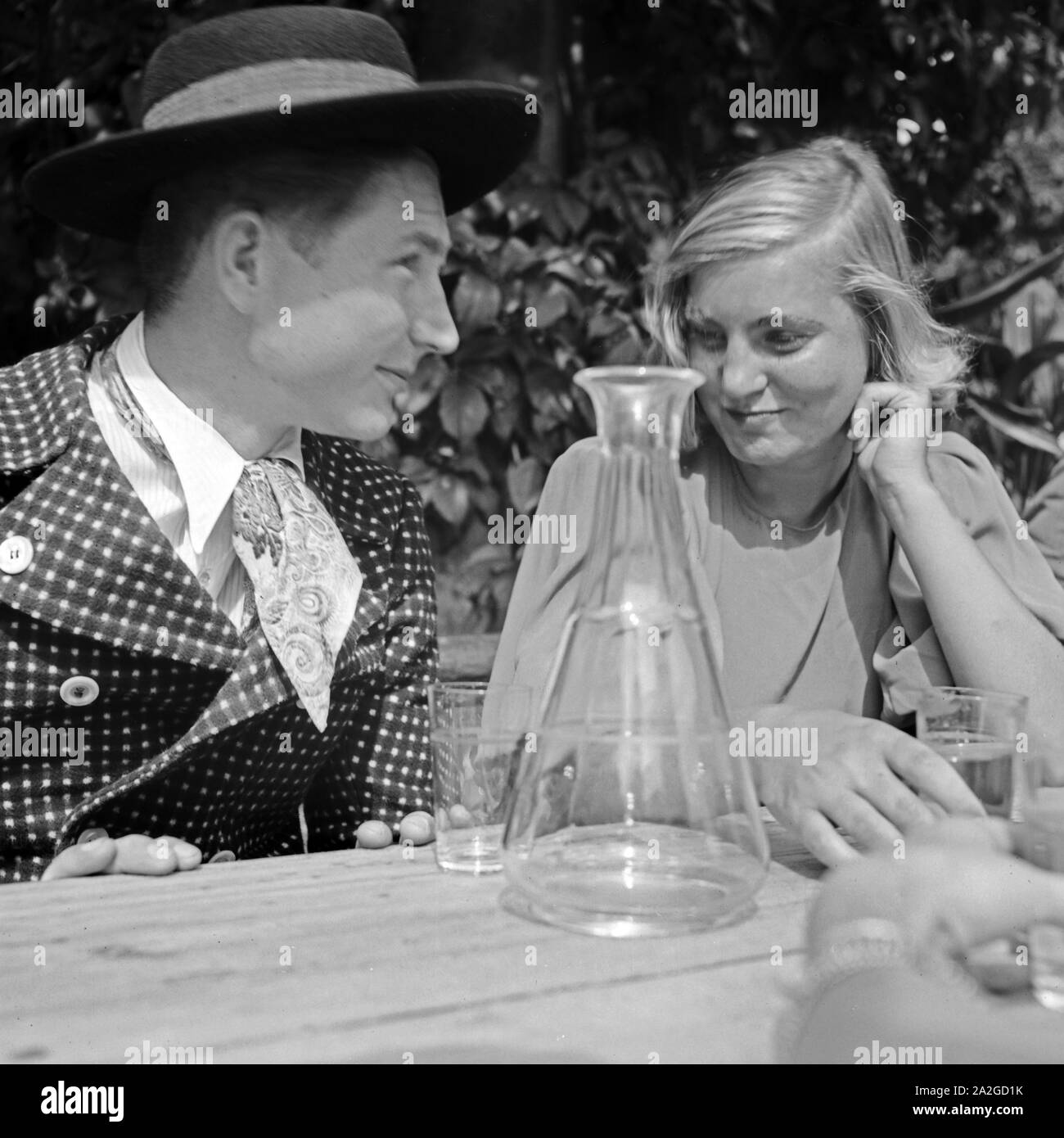 Ein Mann in der Tracht der Wachau trinkt Ein Glas Wein mit einer Frau Österreich 1930er Jahre. Un uomo che indossa array dell'area di Wachau avente un bicchiere di vino con una donna, Austria 1930s. Foto Stock