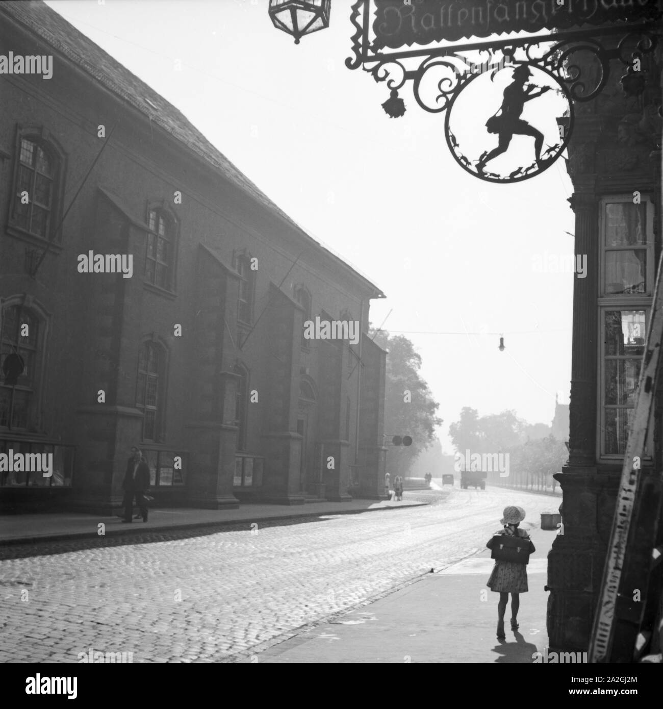 Schulkind vor einem Haus mit dem Rattenfänger simbolo in Hameln an der Weser, Deutschland 1930er Jahre. Scuola ragazza di fronte di una casa con il pifferaio magico simbolo della presso la vecchia città di Hameln sul fiume Weser, Germania 1930s. Foto Stock