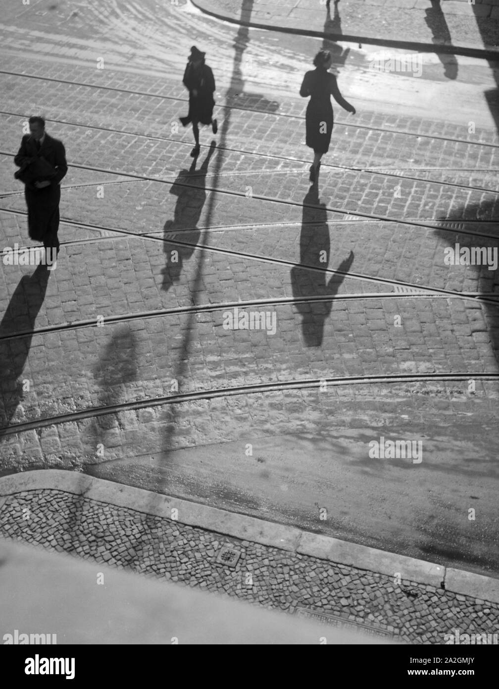 Die Menschen in Berlin werfen lange Schatten, Deutschland 1930er Jahre. persone in una strada di Berlino con le loro ombre, Germania 1930s. Foto Stock