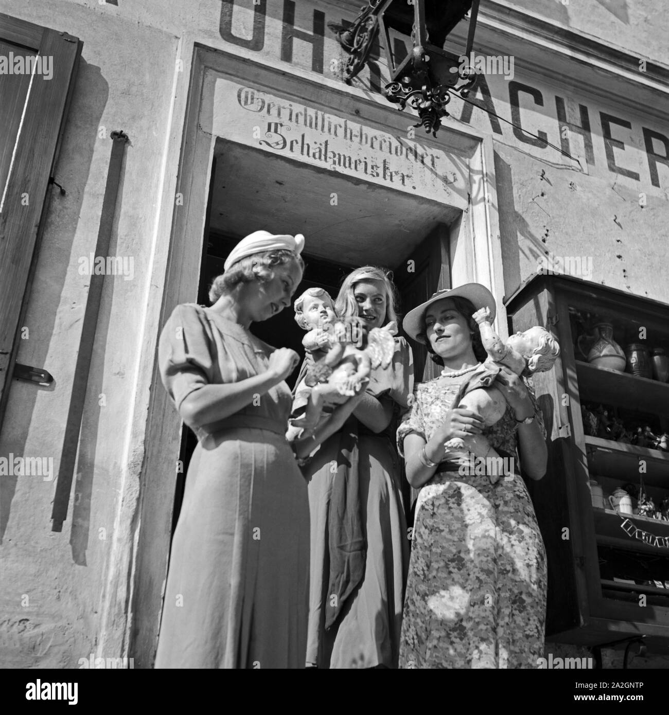 Drei junge Frauen haben in einem Uhrmachergeschäft Kunsthandwerksgegenstände eingekauft, Österreich 1930er Jahre. Tre giovani donne hanno comprato alcuni oggetti di artigianato in un orologio maker's shop, Austria 1930s. Foto Stock