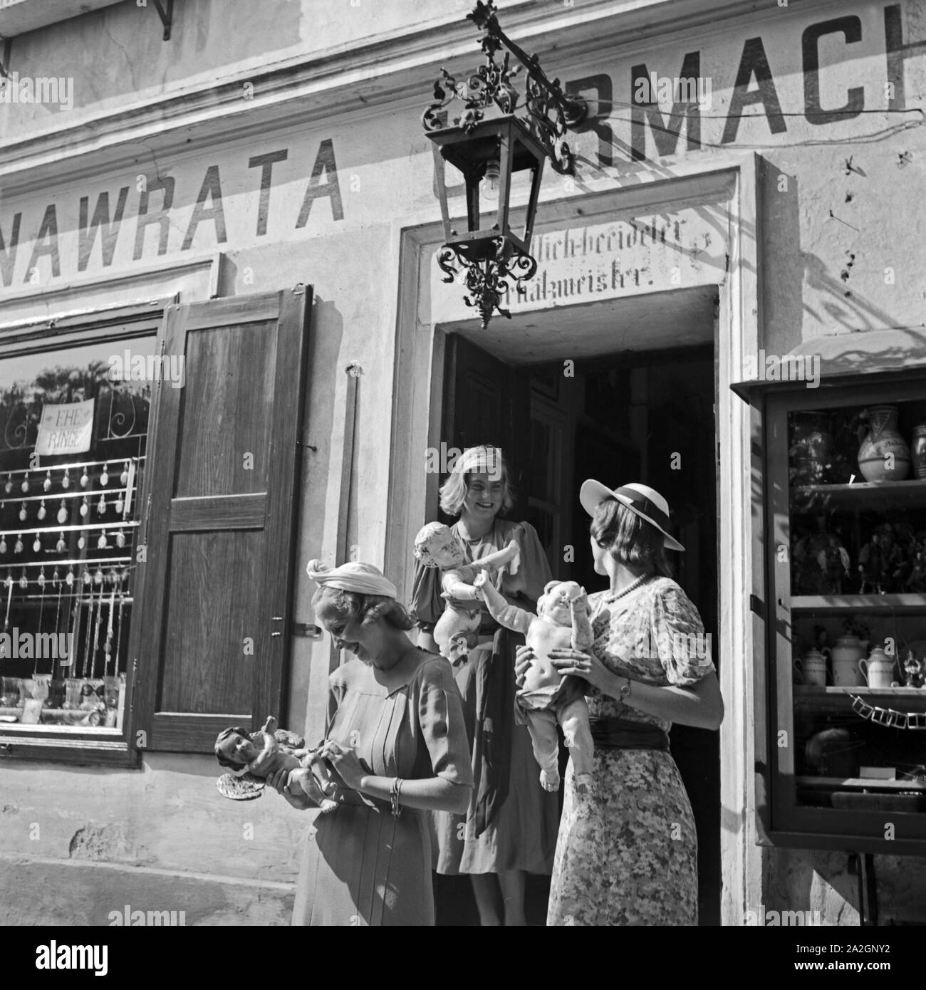 Drei junge Frauen haben in einem Uhrmachergeschäft Kunsthandwerksgegenstände eingekauft, Österreich 1930er Jahre. Tre giovani donne hanno comprato alcuni oggetti di artigianato in un orologio maker's shop, Austria 1930s. Foto Stock