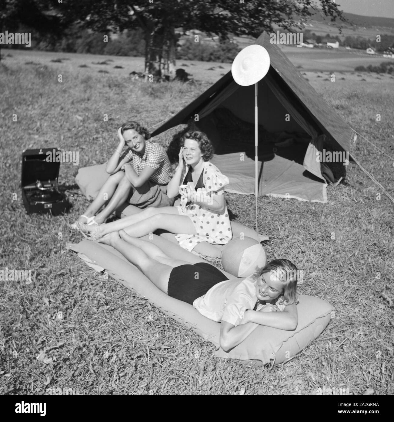 Drei junge Frauen vor dem Klepper Zelt und mit dem Electrola Koffergrammofon, Deutschland 1930er Jahre. Tre giovani donne con una tenda e un grammofono portatile, Germania 1930s. Foto Stock