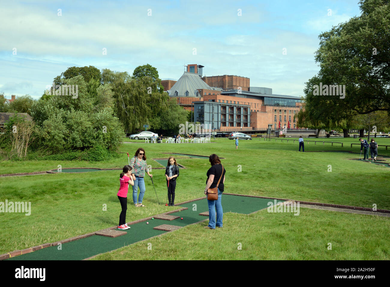 Le donne e i bambini a giocare a minigolf o crazy golf sul terreno di ricreazione di fronte al Royal Shakespeare Theatre di Stratford-upon-Avon Inghilterra Foto Stock