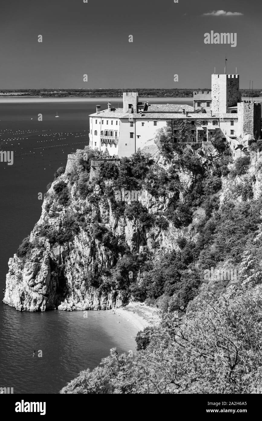 Golfo di Trieste. Alte scogliere tra barche, roccia carsica e antichi castelli. In bianco e nero. Duino. Italia Foto Stock