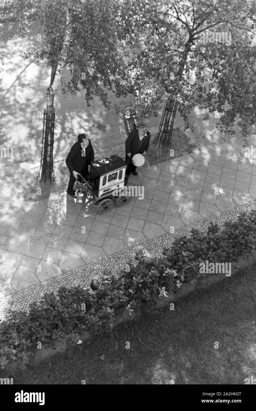 Ein-Mann-Kapelle spielt mit Leierkastenmann im Hof, Deutschland 1930er Jahre. One-man-band e organ grinder giocando al courtyard, Germania 1930s. Foto Stock