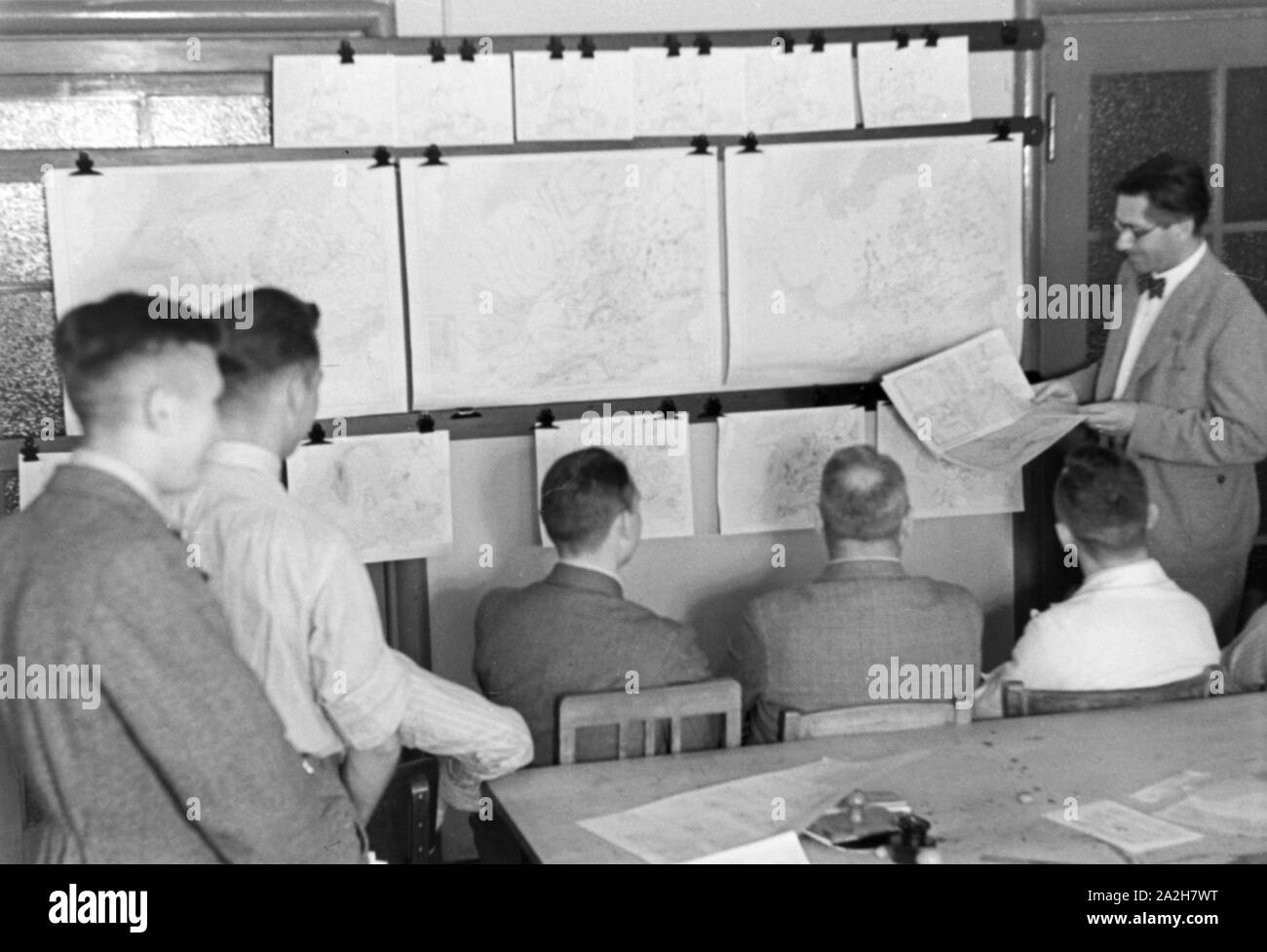 Mitarbeiter der Wetterdienststelle beim Sichten von Landkarten, Deutschland 1930er Jahre. Membro del personale di un ufficio meteorologico lavora con mappe, Germania 1930s. Foto Stock