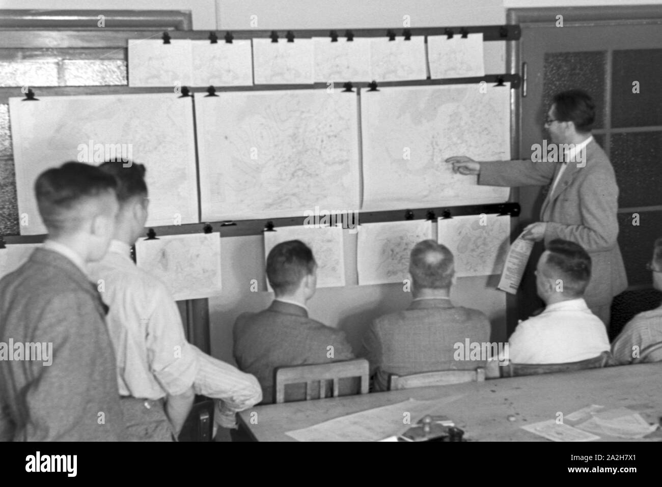 Mitarbeiter der Wetterdienststelle beim Sichten von Landkarten, Deutschland 1930er Jahre. Membro del personale di un ufficio meteorologico lavora con mappe, Germania 1930s. Foto Stock