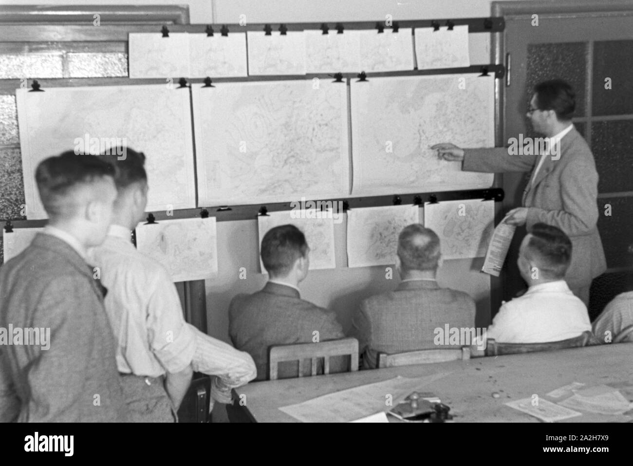 Mitarbeiter der Wetterdienststelle beim Sichten von Landkarten, Deutschland 1930er Jahre. Membro del personale di un ufficio meteorologico lavora con mappe, Germania 1930s. Foto Stock