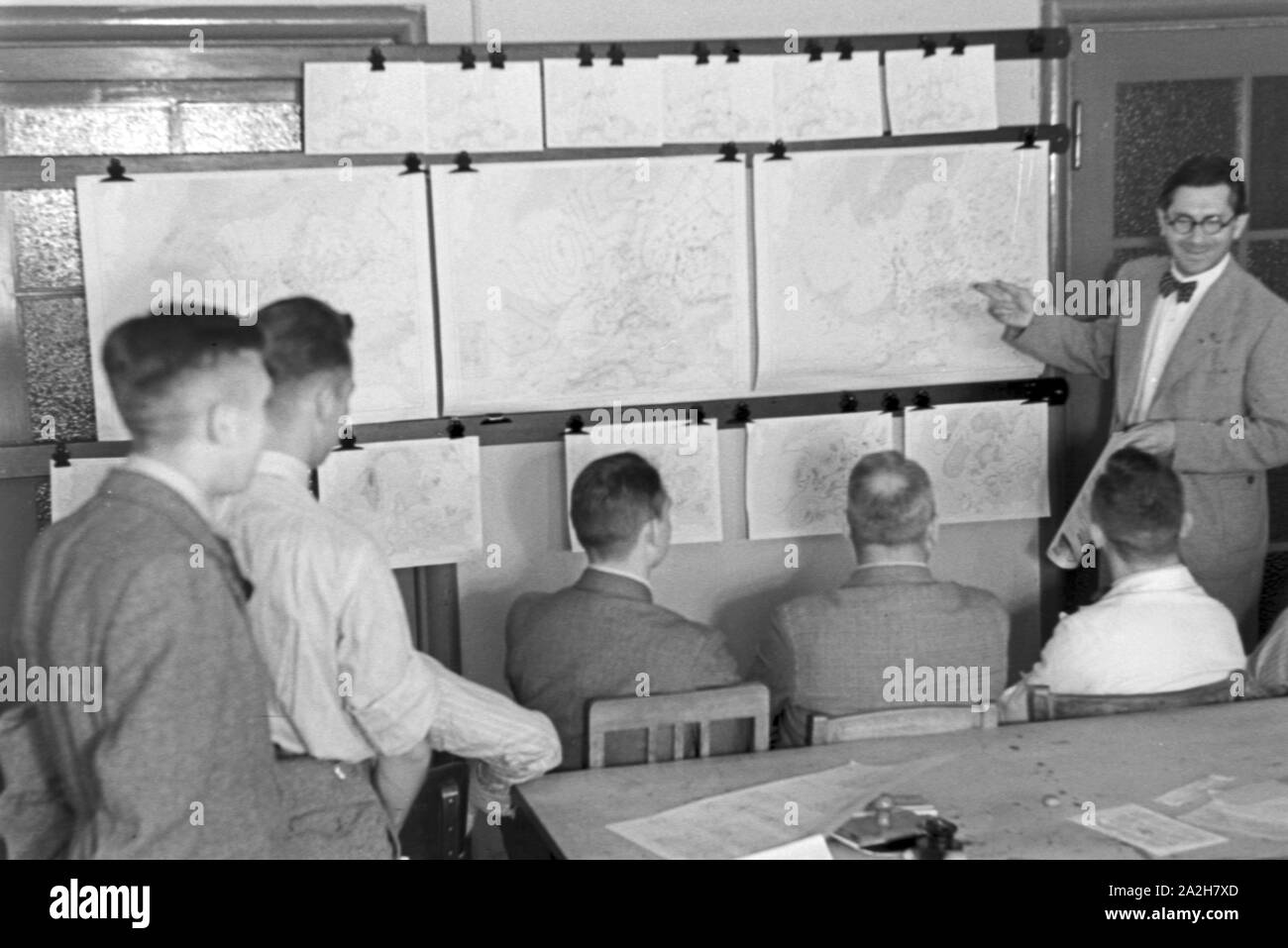 Mitarbeiter der Wetterdienststelle beim Sichten von Landkarten, Deutschland 1930er Jahre. Membro del personale di un ufficio meteorologico lavora con mappe, Germania 1930s. Foto Stock
