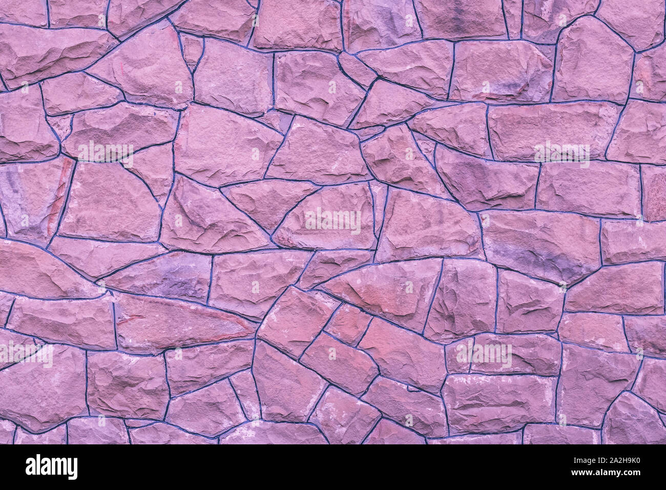 Viola muro di pietra dello sfondo. Luce rosa di tessitura delle rocce. Mattoni schema naturale. Abstract architettura sfondi. Muratura superficie ruvida, moderno de Foto Stock