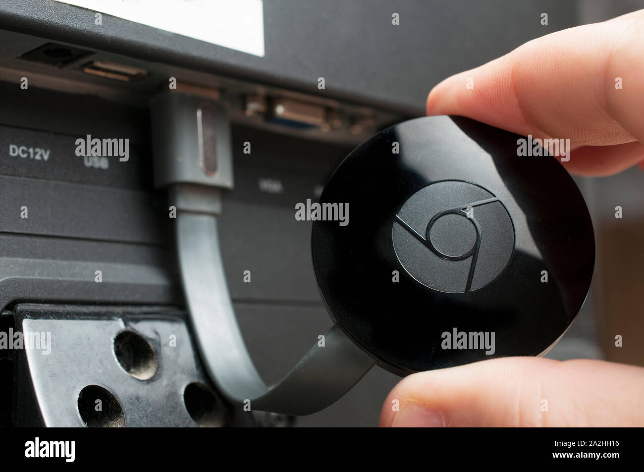 Carrara, Italia - 3 Ottobre 2019 - uomo mostrano un google chromecast dispositivo collegato a un televisore Foto Stock