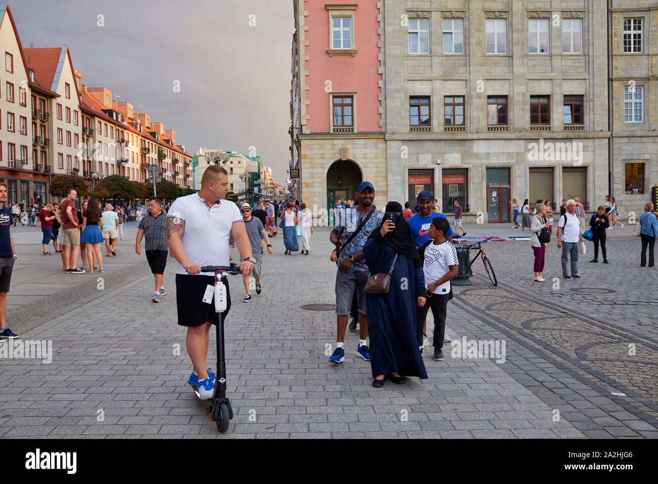 Polen Wroclaw scooter elettrico,passo per l'assunzione. Donna con nikab passeggiate nella città vecchia 8-8-2019 foto Jaco Klamer Foto Stock