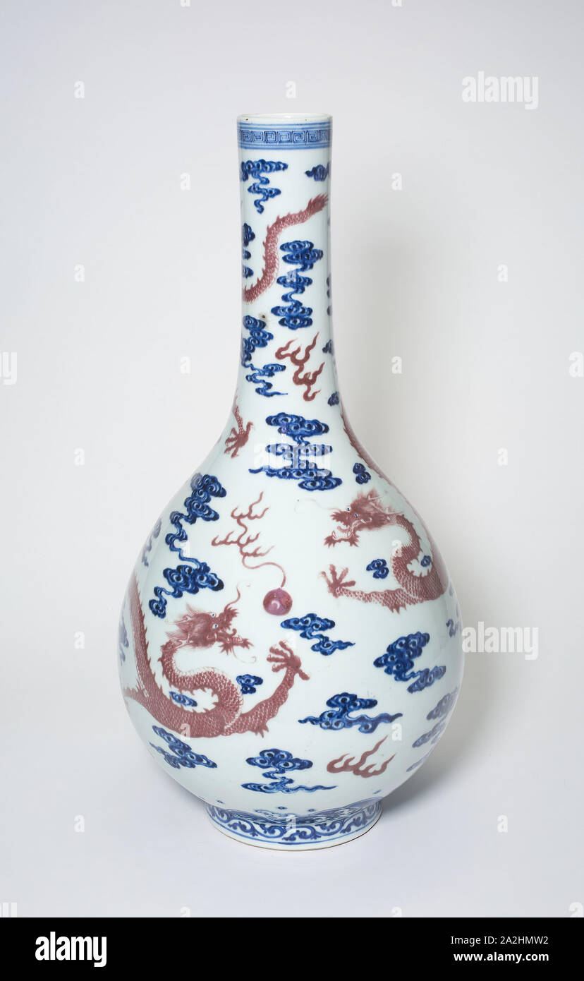 Vaso Long-Necked con draghi a caccia di Flaming perle tra le nuvole stilizzata, dinastia Qing (1644-1911), XVIII secolo, Cina, porcellana dipinta in underglaze blu e rosso rame, H. 47,3 cm (18 5/8 in.), diam. 23,7 cm (9 5/16" Foto Stock