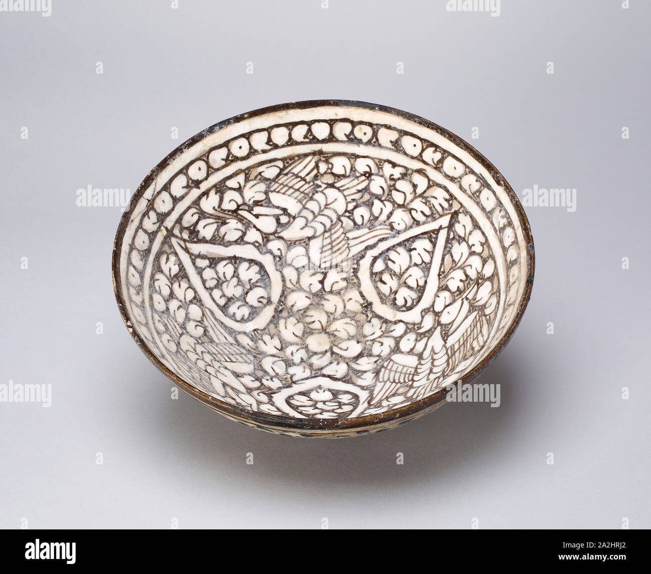 Ciotola con uccelli, dinastia Ilkhanide (1256-1353), fine XIII/inizi del XIV secolo, Iran, probabilmente Kashan, Iran, Fritware dipinta con il grigio e il bianco scivola sotto un velo di smalto trasparente Foto Stock