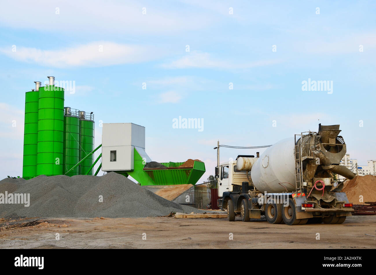 Calcestruzzo impianto di dosaggio. La produzione industriale di calcestruzzo per la costruzione. Miscelatore pesante calcestruzzo i carrelli in attesa di essere caricato sulla fabbrica di calcestruzzo Foto Stock