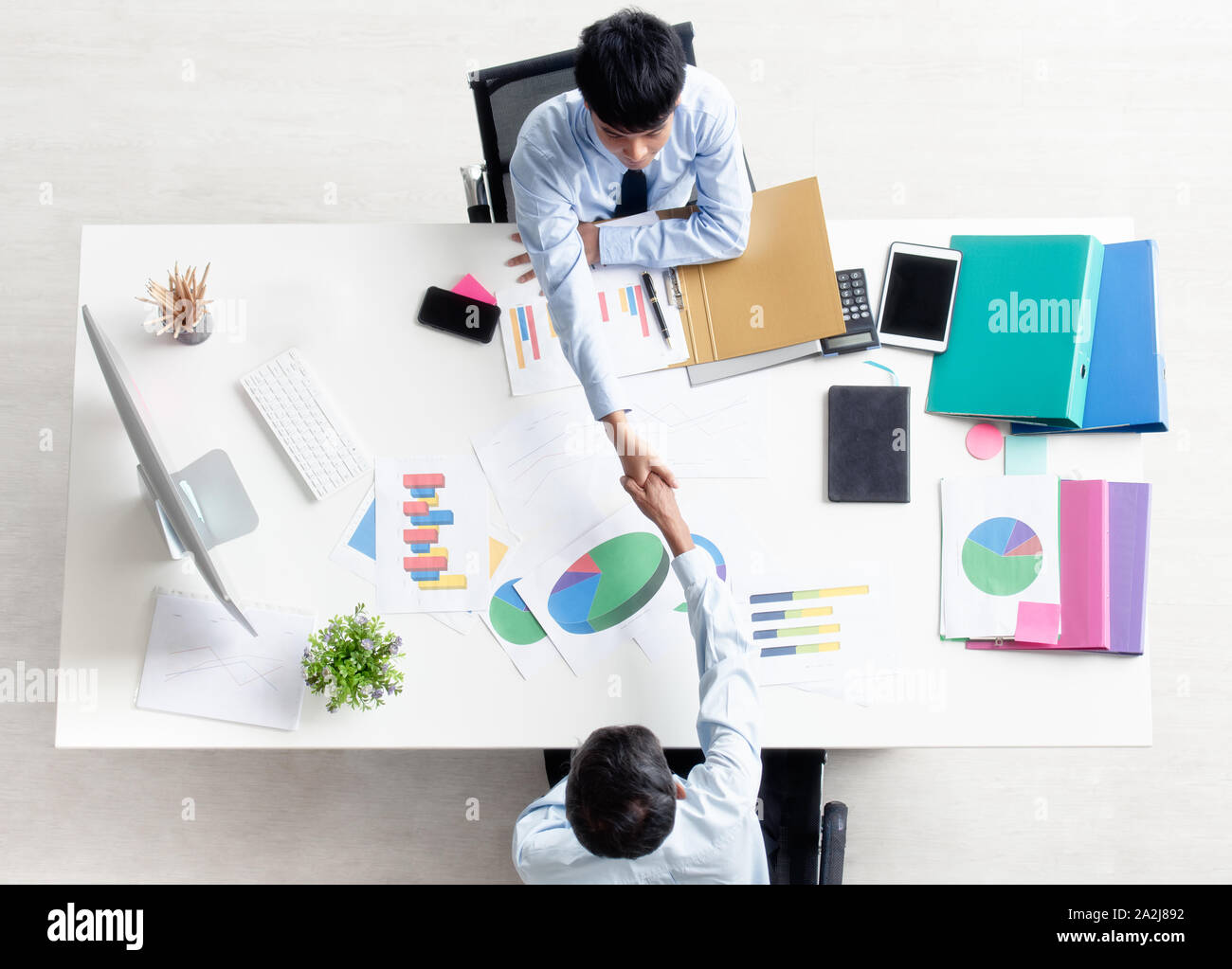 Al di sopra di vista angolare di due vecchi e giovani imprenditori sono seduti e agitando le mani alla scrivania dopo l'accordo commerciale è riuscita. top view phot Foto Stock