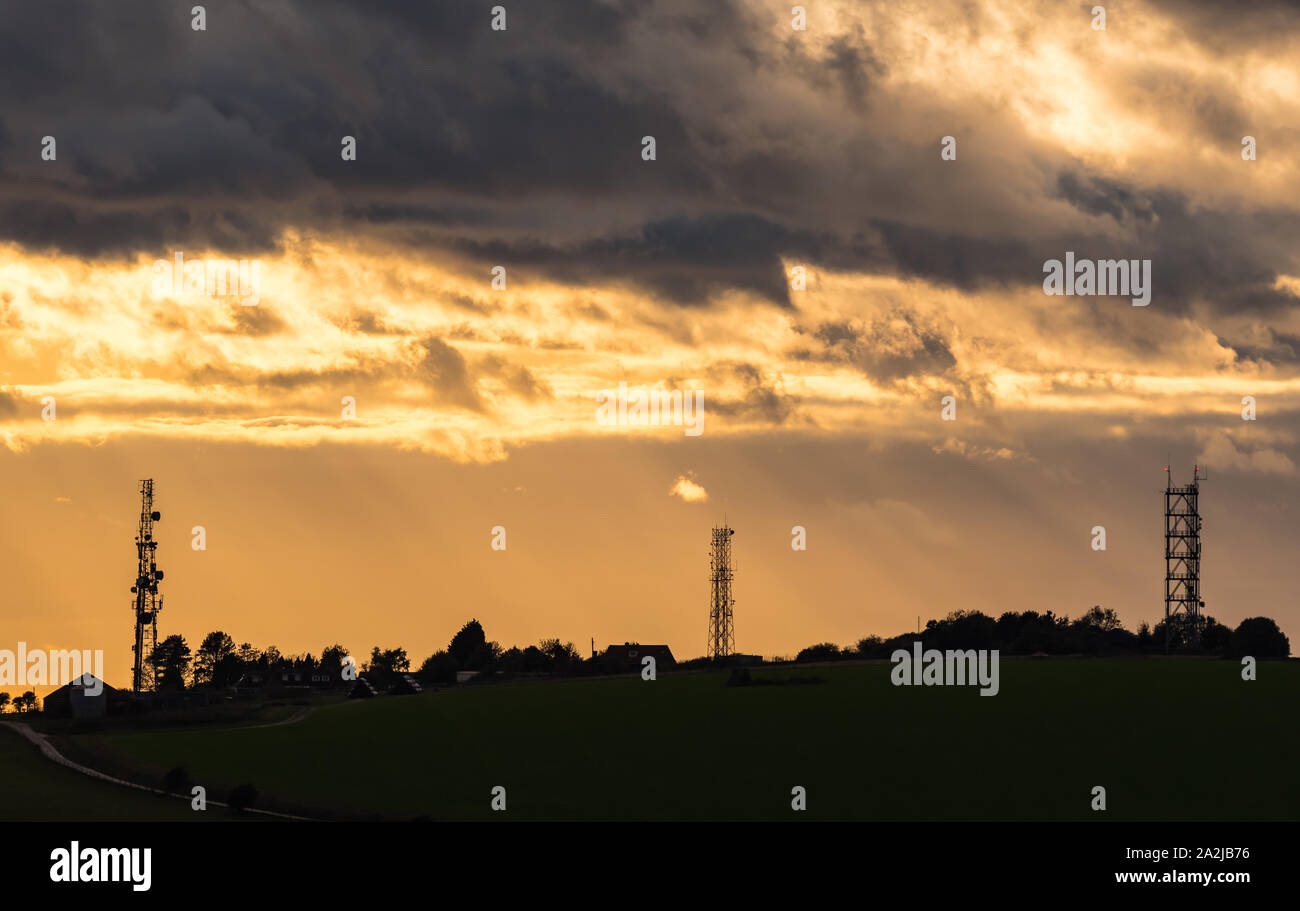 Antenne radio e trasmettitori al tramonto sulla South Downs nel West Sussex, in Inghilterra, Regno Unito. Foto Stock