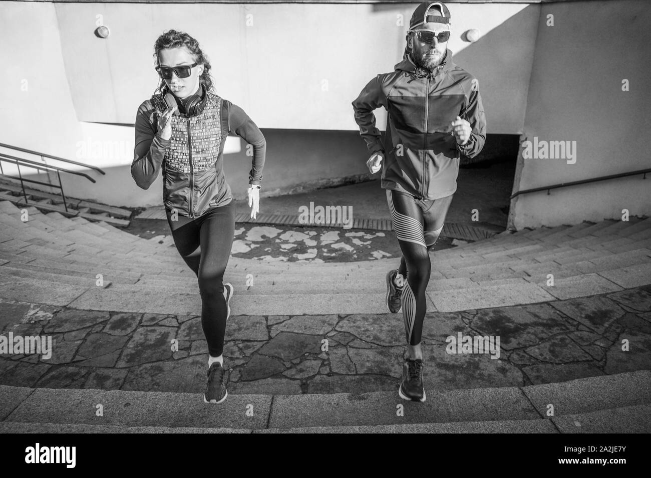 Runner Fitness matura in esecuzione su per le scale. Coppia attiva outdor jogging al mattino Foto Stock