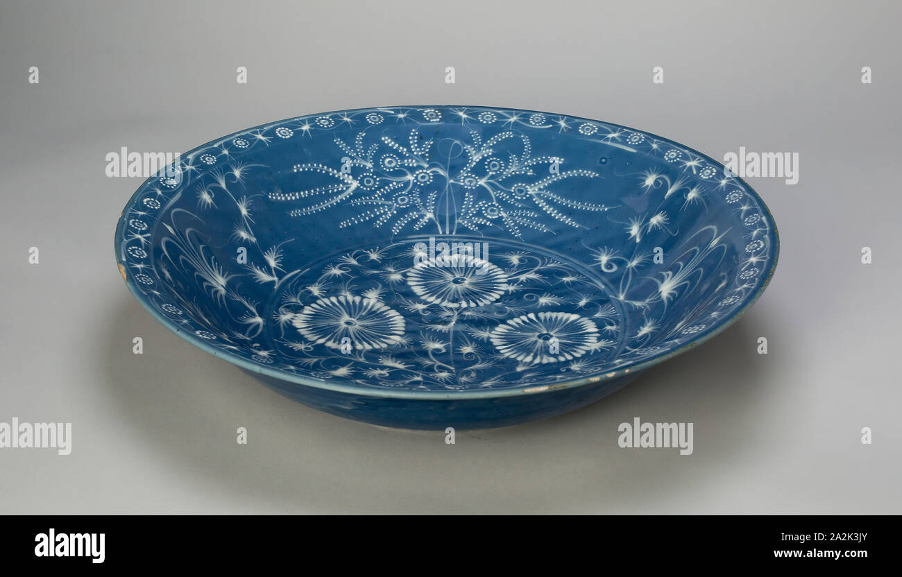 Il piatto con i crisantemi e motivi floreali stilizzate volute, dinastia Ming (1368-1644), xv secolo, Cina, grès bianca con decorazione di slittamento su polvere di smalto blu, H. 8.9 cm (3 1/2 in.), diam. 40,5 cm (15 15/16 in Foto Stock