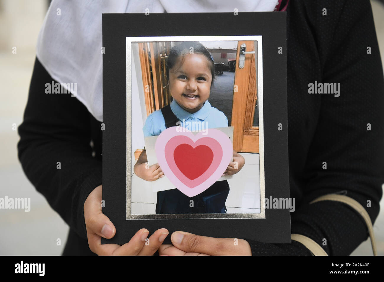 Shelina iniziata, detiene una foto dei suoi cinque-anno-vecchio figlia Tafida Raqeeb, al di fuori della Royal Courts of Justice di Londra dove lei e suo marito Mohammed Raqeeb, hanno vinto una decisione in merito a se il trattamento deve essere interrotto per lei. Foto Stock