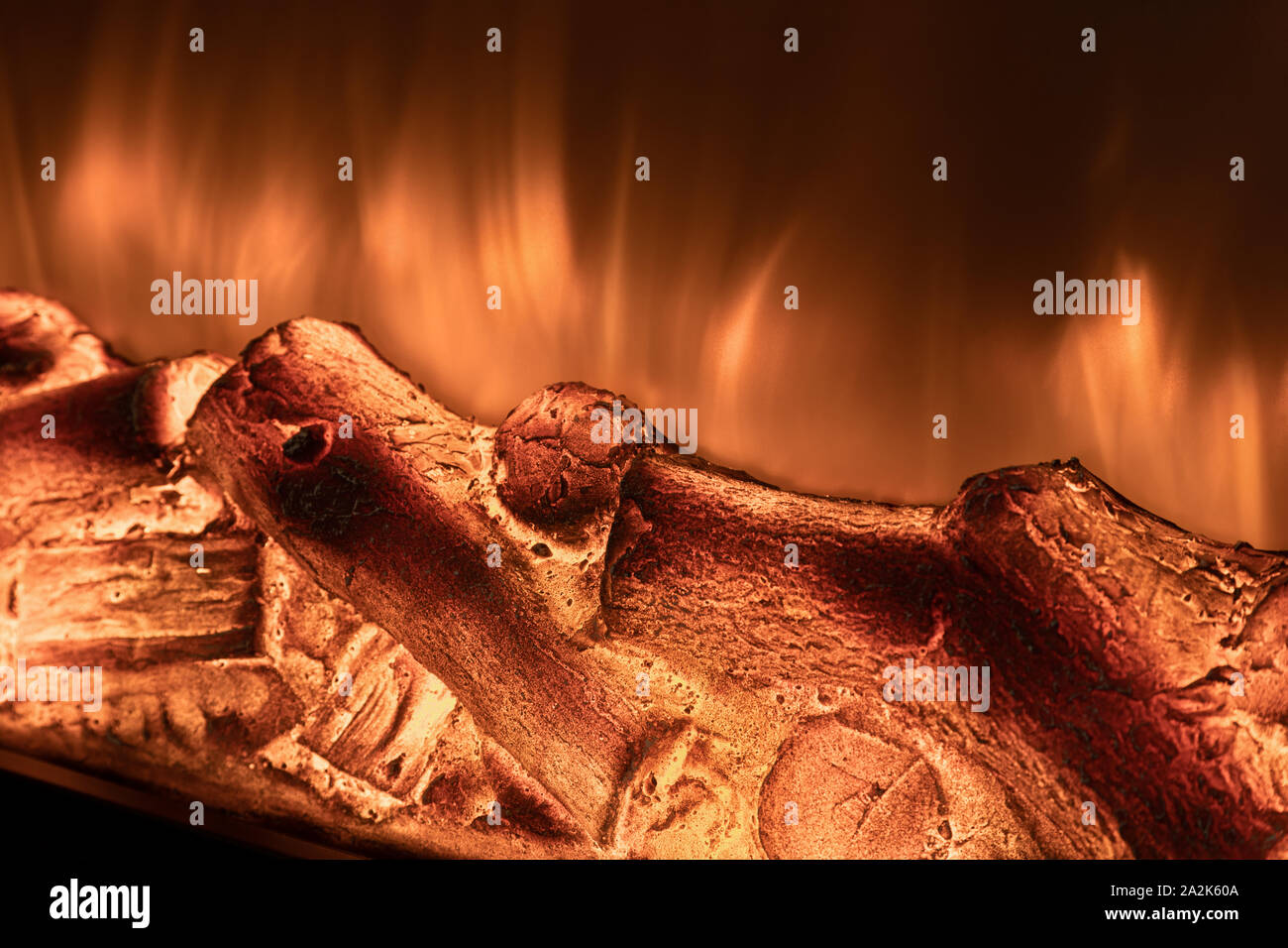 Caminetto elettrico con il fuoco e la legna da ardere closeup. Foto Stock