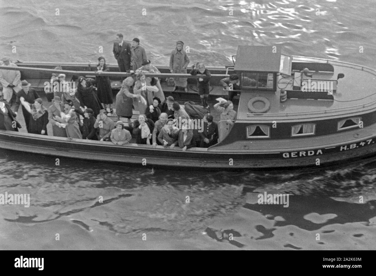 Die Barkasse 'Gerda', besetzt mit Angehörigen, begleitet das Walfangfabrikschiff 'Jan Wellem' noch ein Stück aus dem Hafen Wesermünde heraus, Deutschland 1930er Jahre. La chiatta " Gerda' che accompagnano la nave officina 'Jan Wellem' fuori del porto di Wesermuende, Germania 1930s. Foto Stock