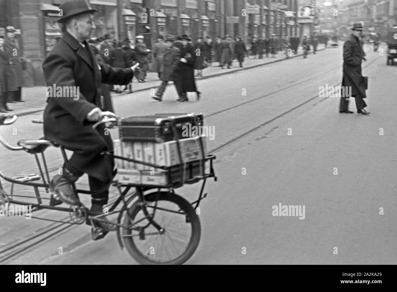 Ein Mann auf einem Tandemfahrrad in der Innenstadt von Leipzig Zur Zeit der Messe, Deutschland 1940er Jahre. Un uomo su una bicicletta in tandem nella città di Lipsia durante la fiera, Germania 1940s. Foto Stock