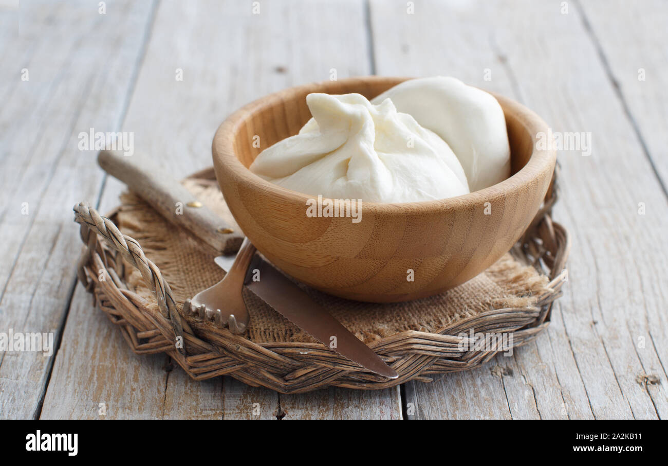 Formaggio italiano burrata con il pane su un sfondo di legno Foto Stock